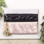 Women's clutch bag: Double zippers, shimmery rose gold, black and silver with large gold tassle